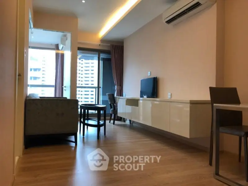 Modern living room with sleek furniture and balcony view in urban apartment.