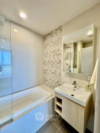 Modern bathroom with sleek design, featuring a bathtub and stylish vanity.