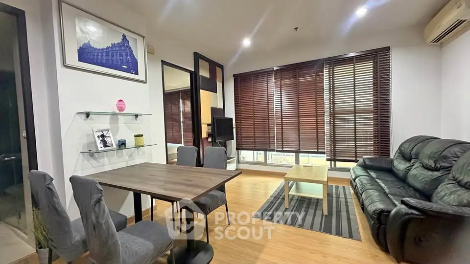 Spacious living room with modern decor and large windows in a stylish apartment.