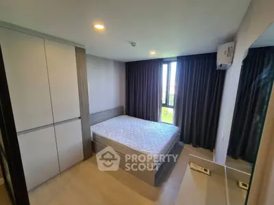 Modern bedroom with large window and built-in wardrobe in a stylish apartment.