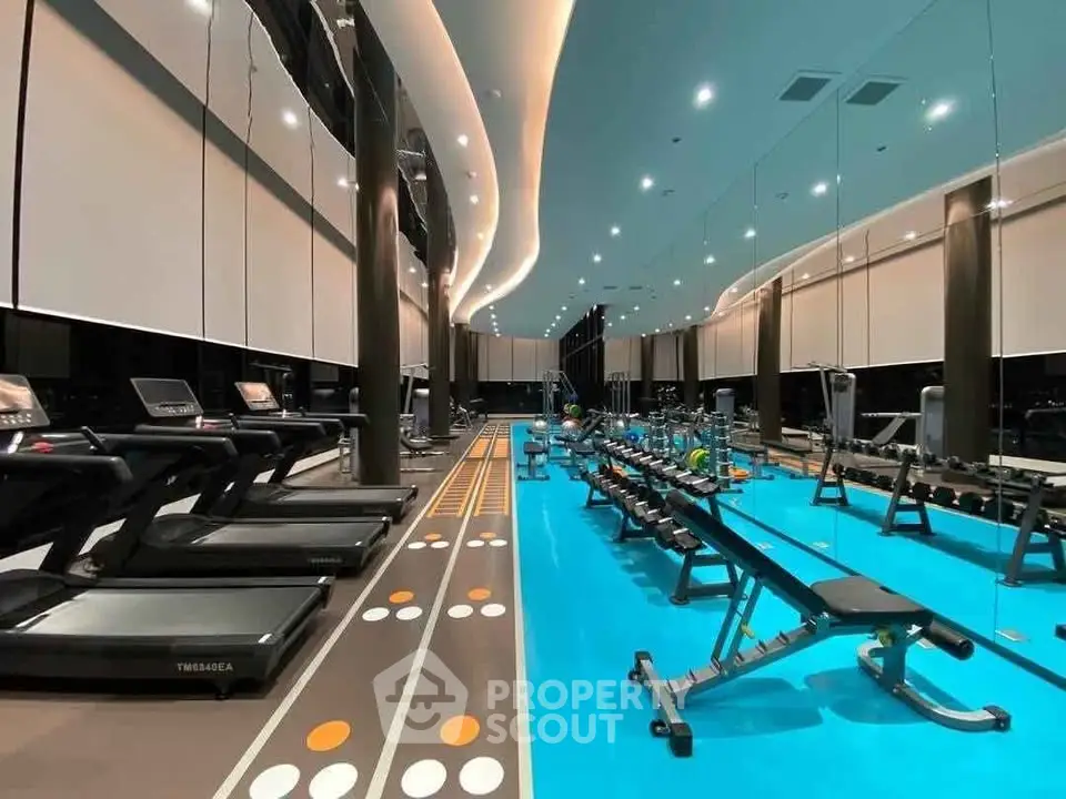 Luxurious modern gym with state-of-the-art equipment and sleek design in upscale residential building.