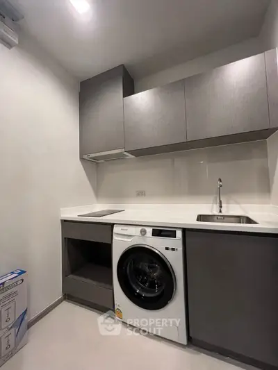 Modern kitchen with sleek cabinetry and built-in washing machine