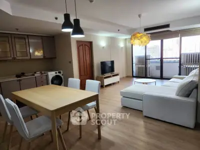 Spacious modern living room with open kitchen, stylish furniture, and natural light.