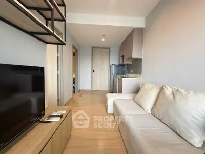 Modern living room with sleek furniture and open kitchen layout in a stylish apartment.