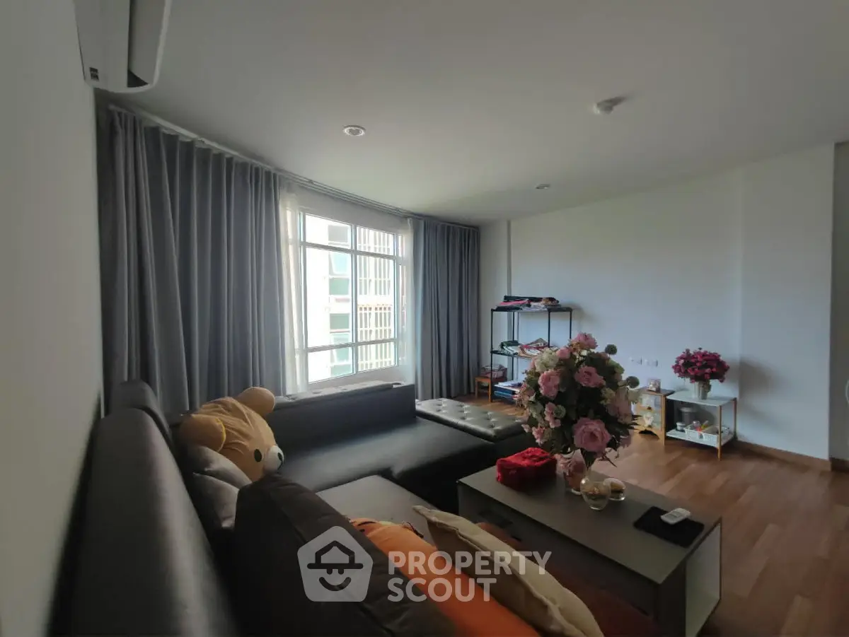Spacious living room with modern decor and large window for natural light