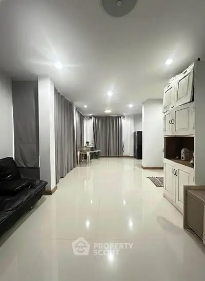 Spacious living room with modern furnishings and ample natural light, perfect for relaxation and entertainment.