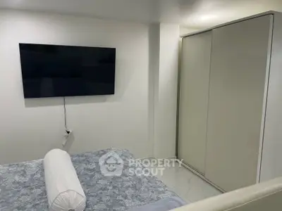 Modern bedroom with wall-mounted TV and sliding wardrobe