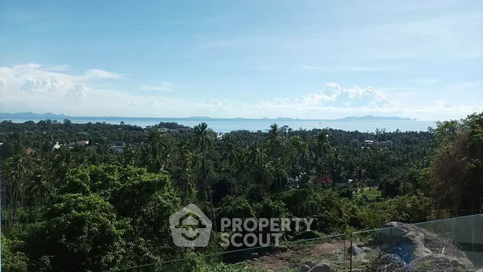 Stunning panoramic view of lush greenery and ocean horizon from a high vantage point, perfect for serene living.