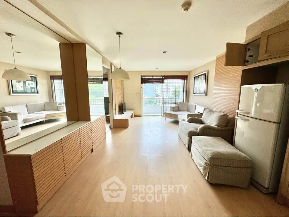 Spacious living room with modern decor and large windows offering natural light and a cozy ambiance.