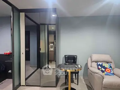 Modern living room with sleek mirrored closet and cozy seating area.