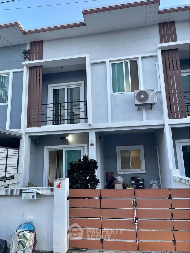 Modern two-story townhouse with balcony and gated entrance