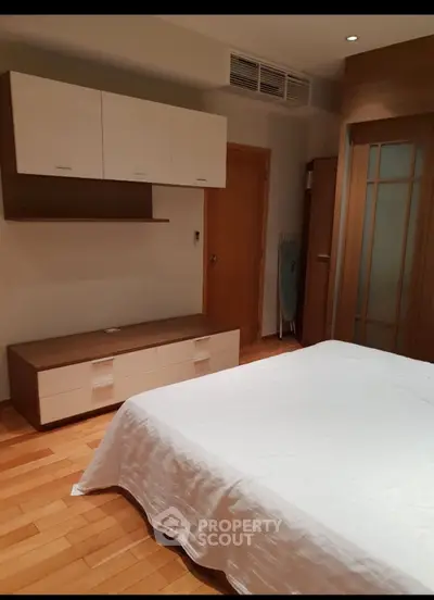 Modern bedroom with wooden flooring and stylish storage solutions