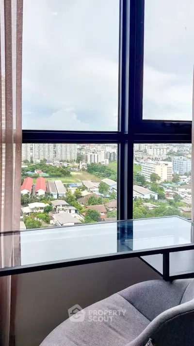 Stunning cityscape view from a modern high-rise apartment window, featuring a sleek glass desk.