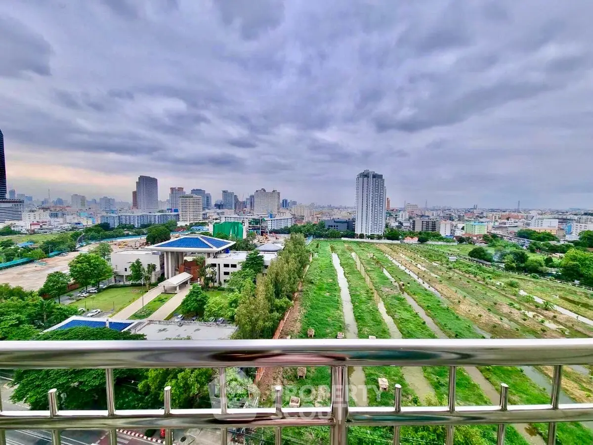 Stunning cityscape view from a high-rise balcony overlooking urban skyline and green spaces.
