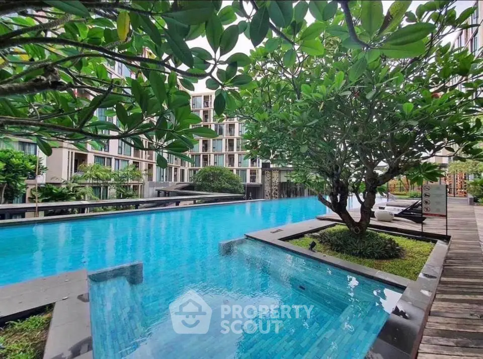 Luxurious condo with stunning pool and lush greenery, perfect for relaxation and leisure.