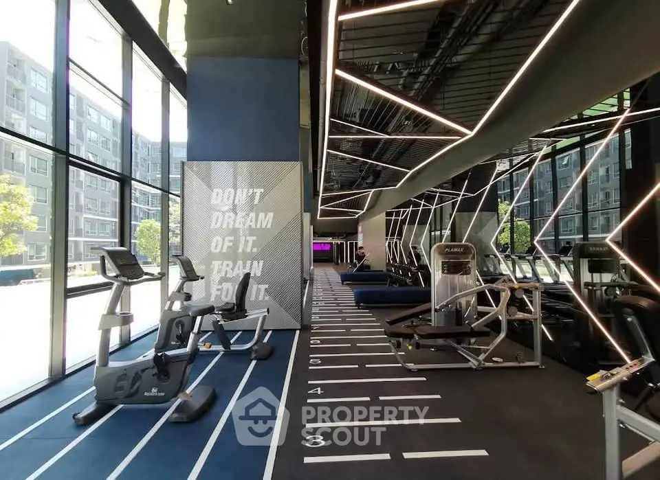 Modern gym with state-of-the-art equipment and motivational decor in a luxury apartment complex.