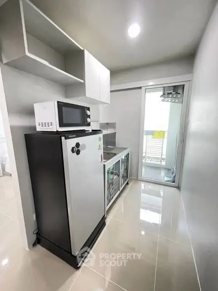 Modern kitchen with sleek appliances and balcony access in a stylish apartment.