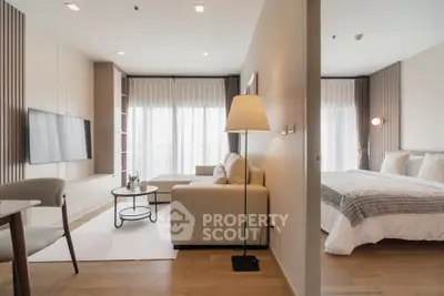 Modern open-plan living room and bedroom with elegant decor and natural light.