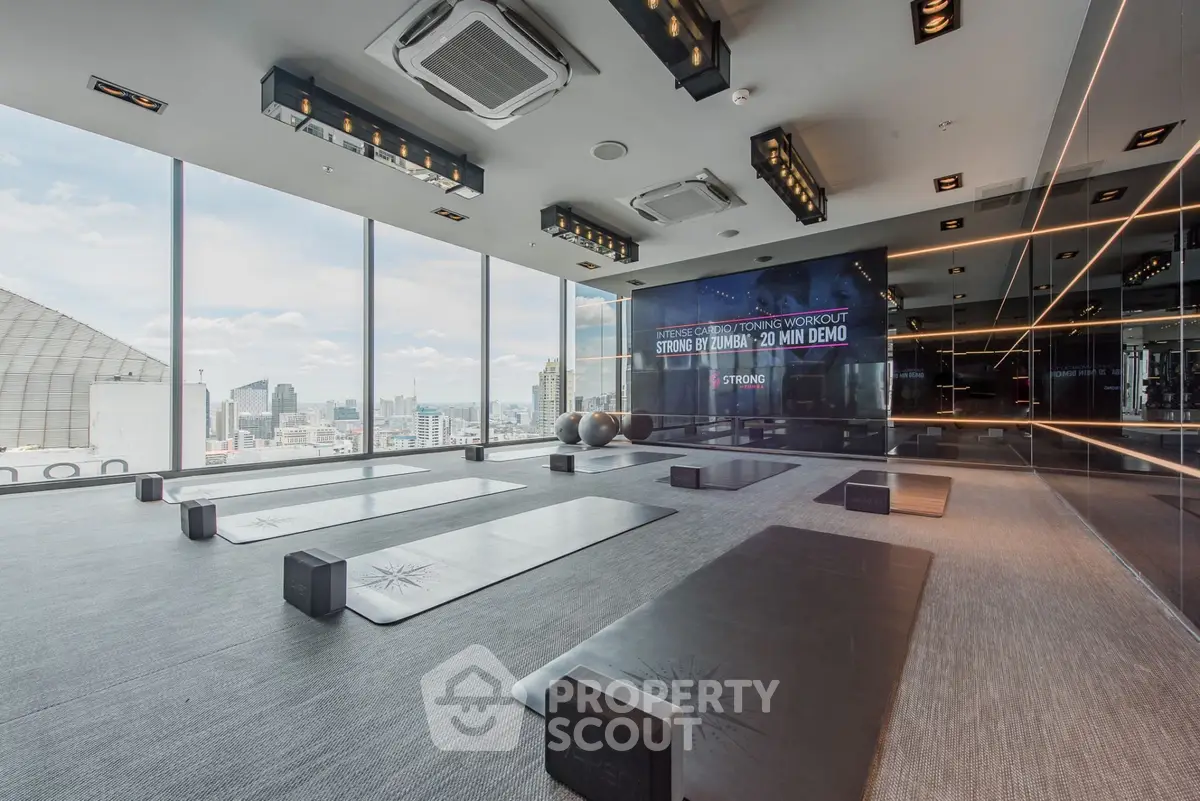 Luxurious high-rise gym with panoramic city views and modern fitness equipment.