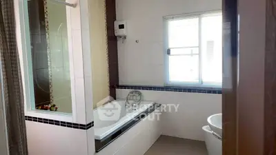 Modern bathroom with bathtub and natural light from window