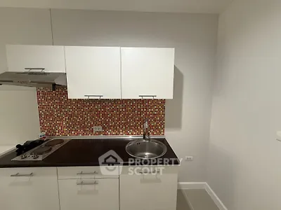 Modern compact kitchen with sleek white cabinets and mosaic backsplash