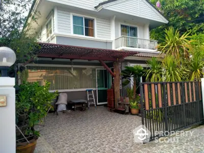 Charming two-story house with lush garden and spacious driveway in serene neighborhood.