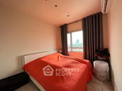 Cozy bedroom with city view, featuring a large window and modern furnishings.