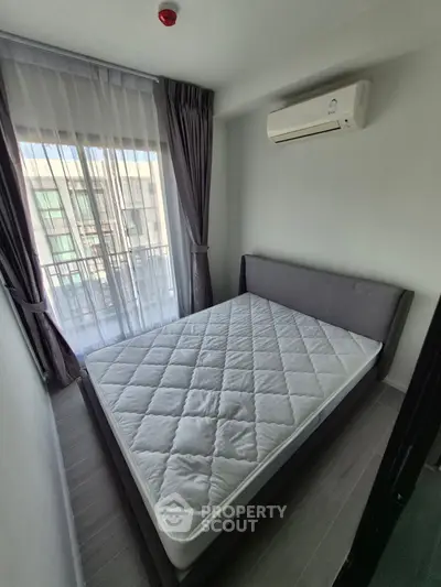 Cozy bedroom with modern air conditioning and large window for natural light.