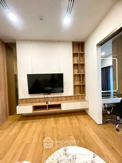Modern living room with wooden flooring and built-in TV unit