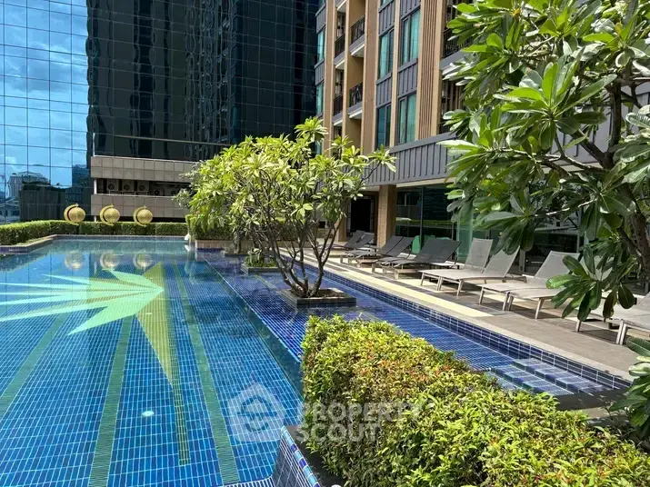Luxurious apartment complex with stunning outdoor pool and lush greenery.