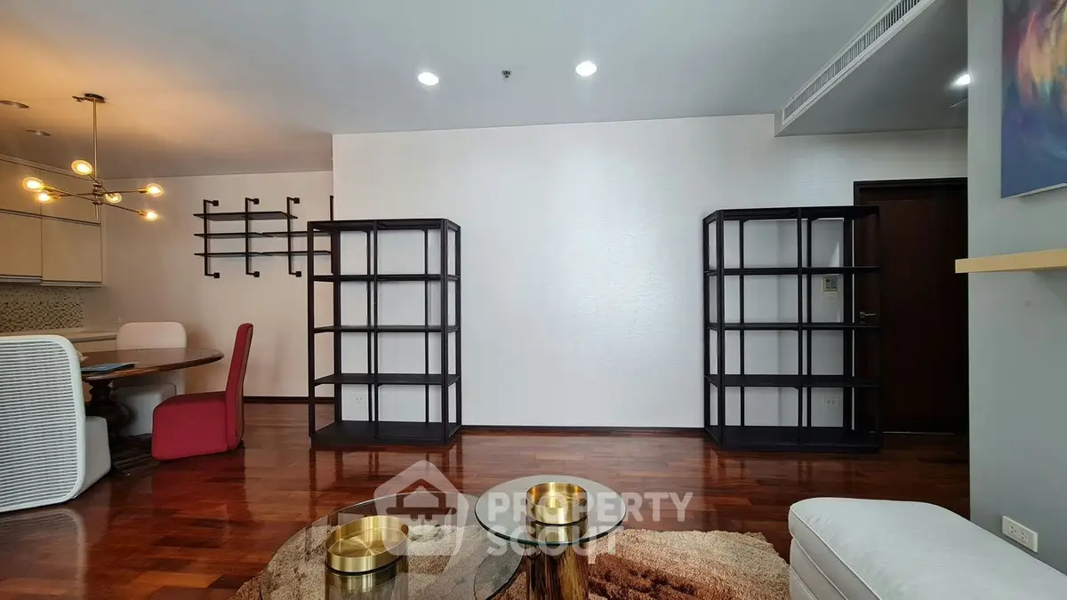 Spacious living room with modern decor and hardwood floors in a stylish apartment.