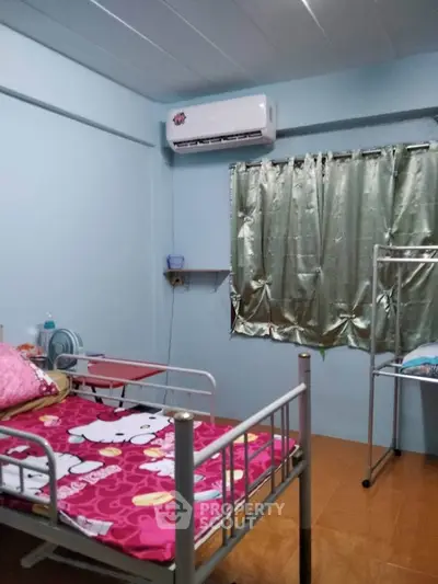 Cozy bedroom with air conditioning and colorful bedding, perfect for a comfortable living space.