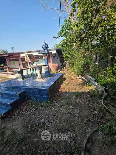 Charming rural property with traditional outdoor shrine and lush greenery, perfect for serene living.