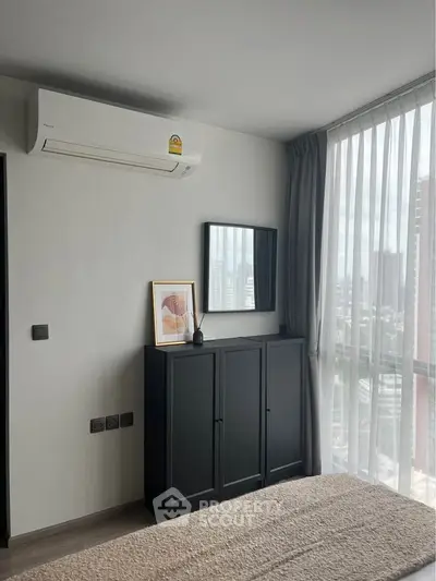 Modern bedroom with large window and air conditioning in urban apartment