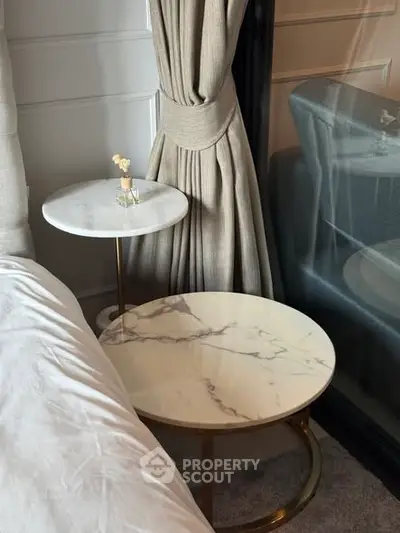 Elegant bedroom corner with marble side tables and luxurious curtains