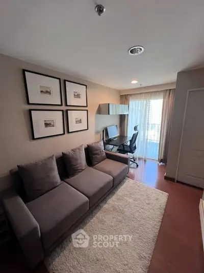 Modern study room with stylish sofa and desk, featuring large windows for natural light.