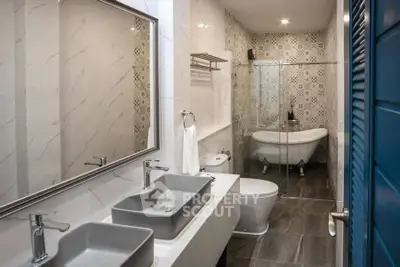 Luxurious bathroom with elegant design featuring double sinks and a classic clawfoot bathtub.