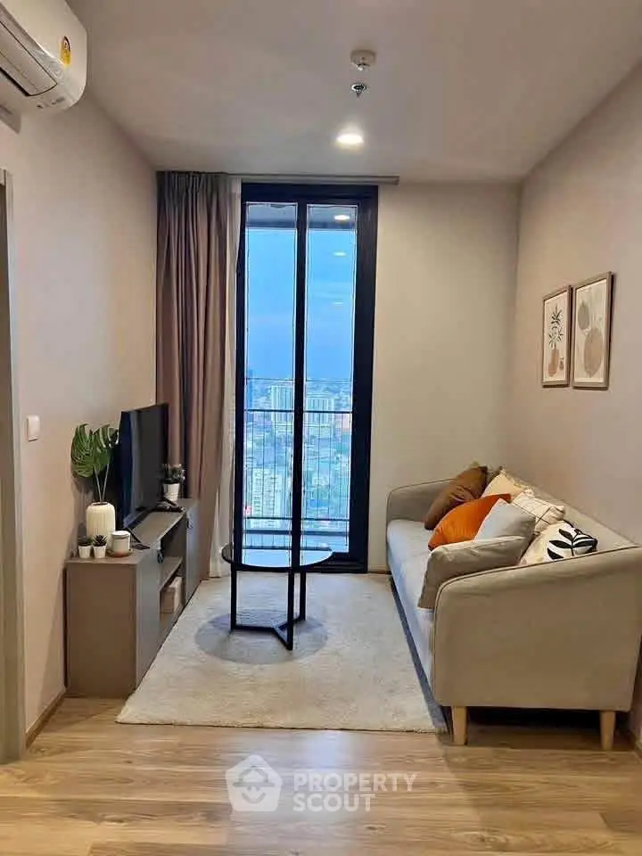 Modern living room with cozy sofa and city view from large window.
