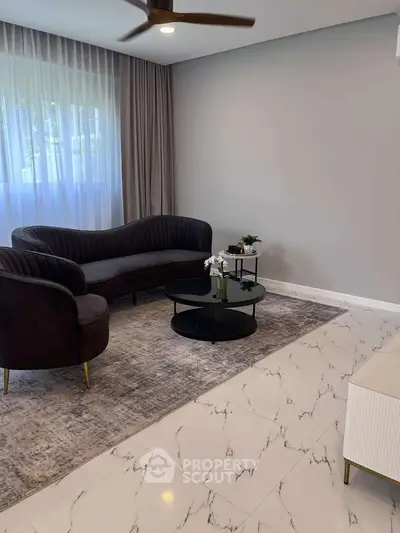 Elegant living room with modern furniture and marble flooring, featuring a stylish sofa and coffee table.