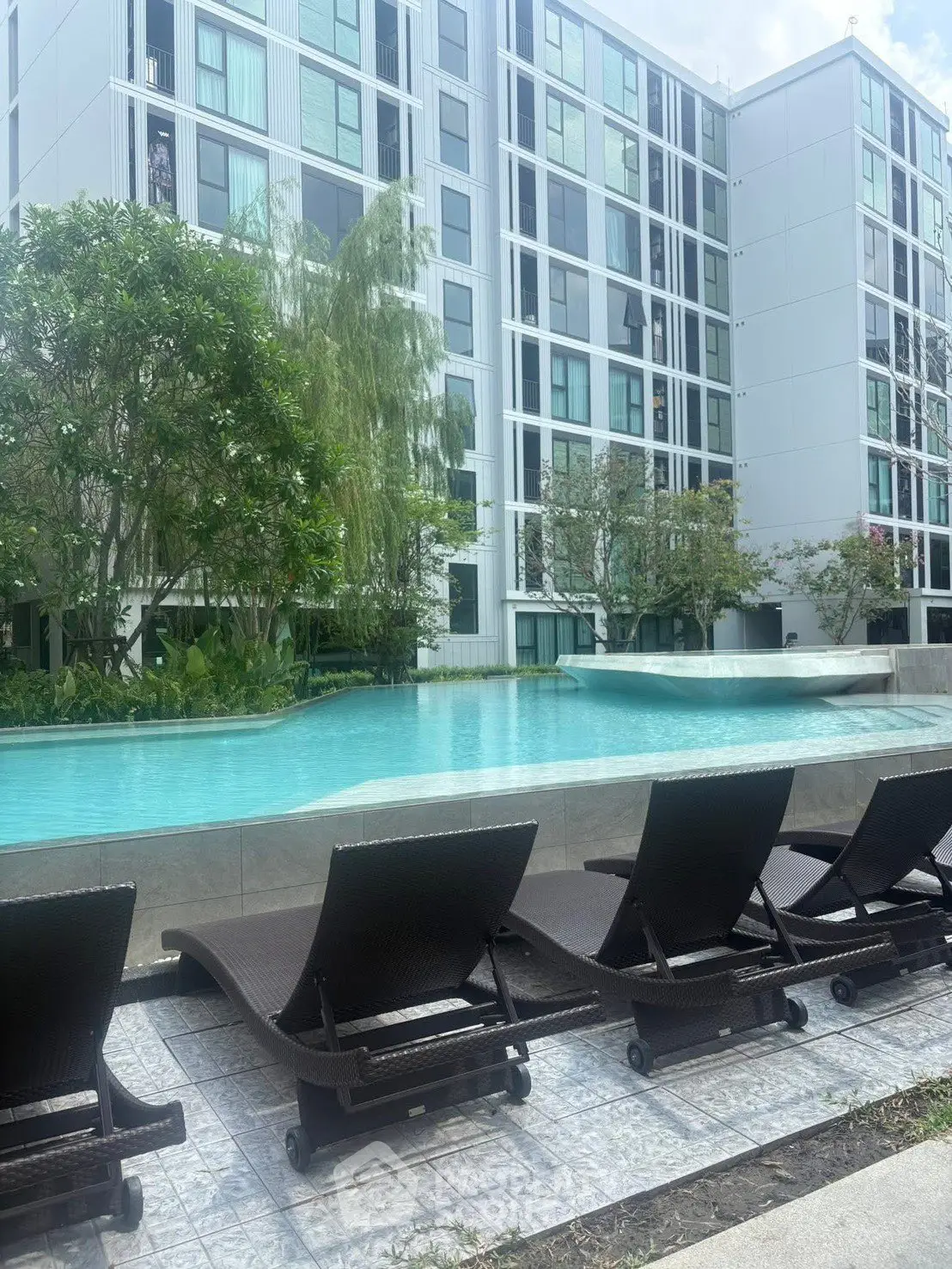 Luxurious apartment complex with a stunning pool and modern design.
