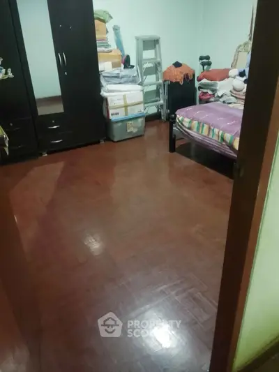 Cozy bedroom with wooden flooring and ample storage space