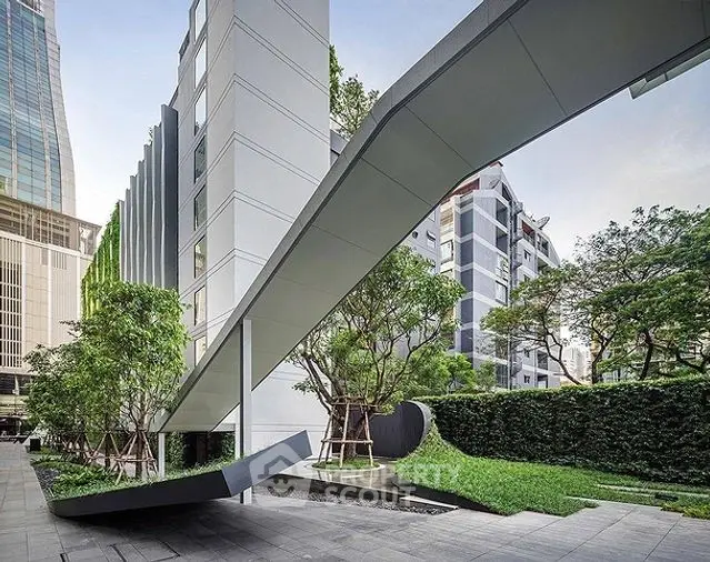 Modern architectural exterior with sleek design and lush greenery in urban setting.