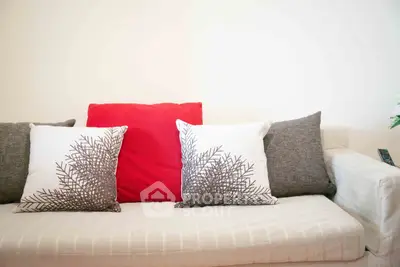 Cozy living room with stylish cushions on a modern sofa, perfect for relaxation.