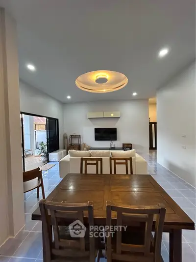 Spacious living room with modern decor and open layout, featuring a cozy seating area and elegant dining space.