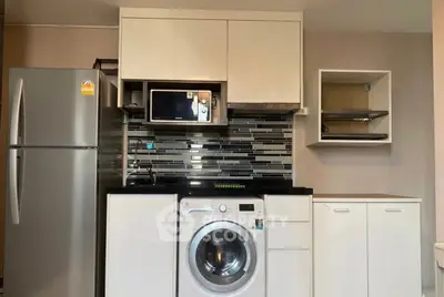 Modern kitchen with sleek appliances including fridge, microwave, and washing machine.