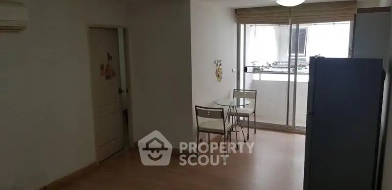 Cozy dining area with natural light and modern furniture in a compact apartment.