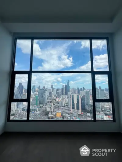 Stunning cityscape view from high-rise apartment window with expansive skyline.