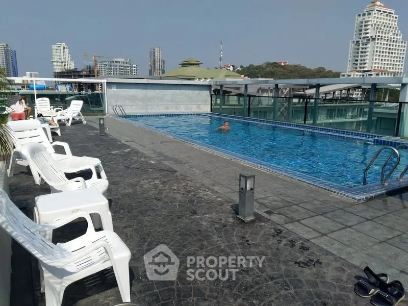 Luxurious rooftop pool with city skyline views and relaxing lounge chairs.