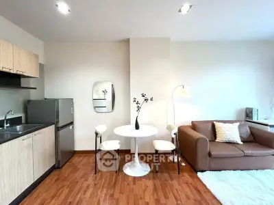 Modern open-plan living room with cozy seating and compact kitchen area.