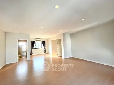 Spacious empty living room with wooden flooring and natural light